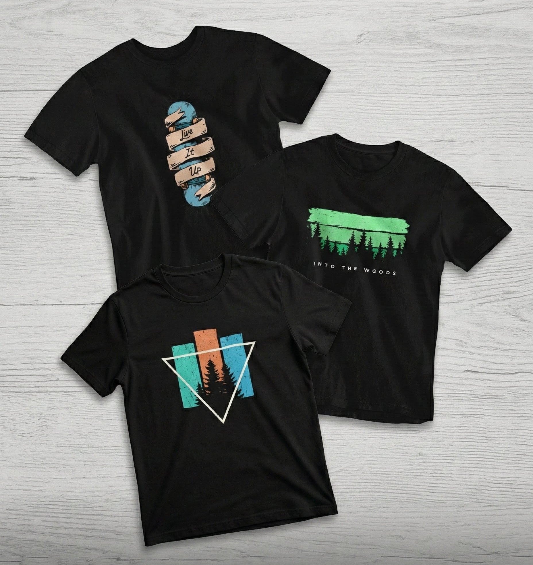 Three black t-shirts with nature-themed designs on a light wooden surface