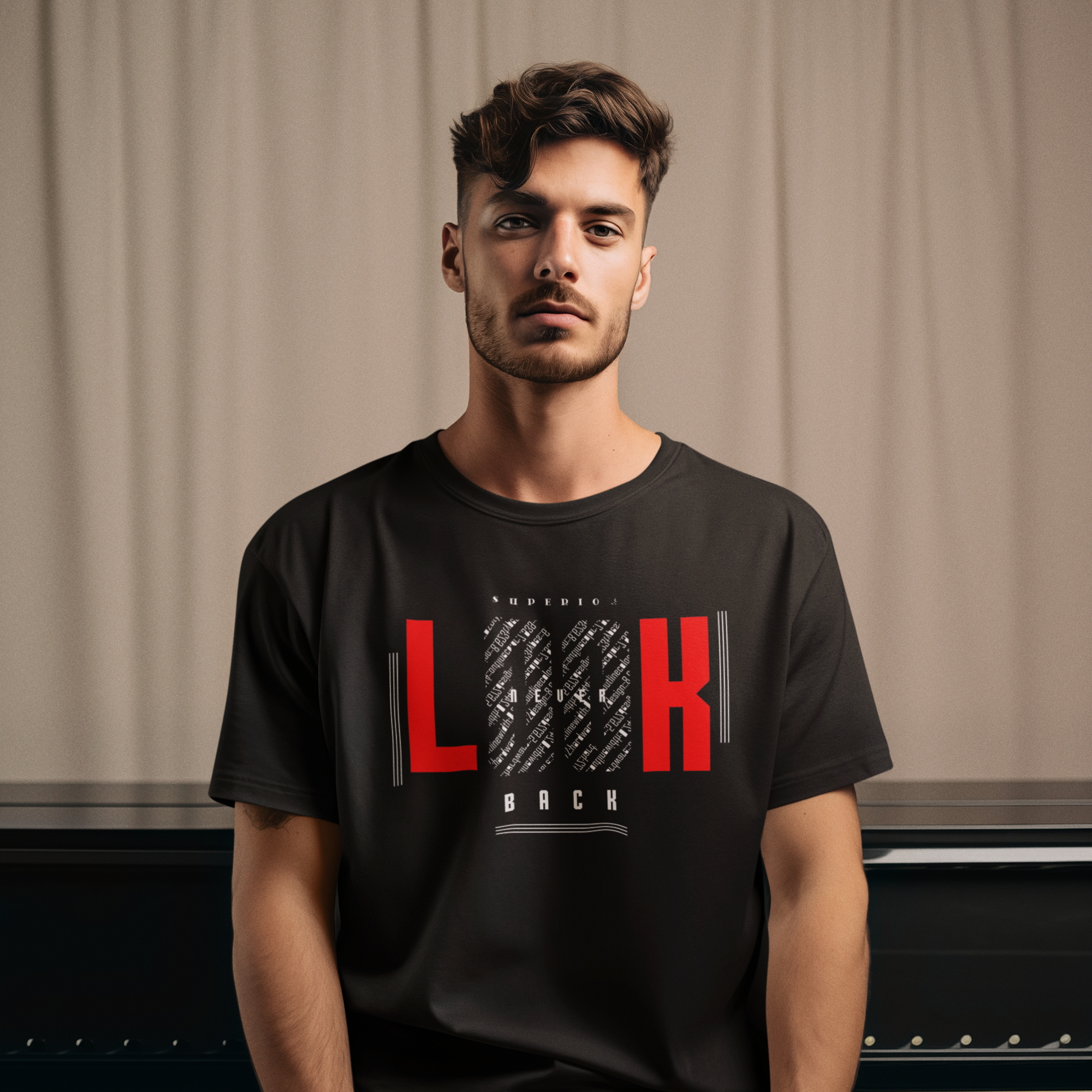 Man wearing a black t-shirt with red and white text sitting in front of a piano.